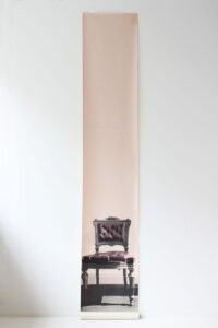 a pink chair, pictured on a hand printed wallpaper by Deborah Bowness.